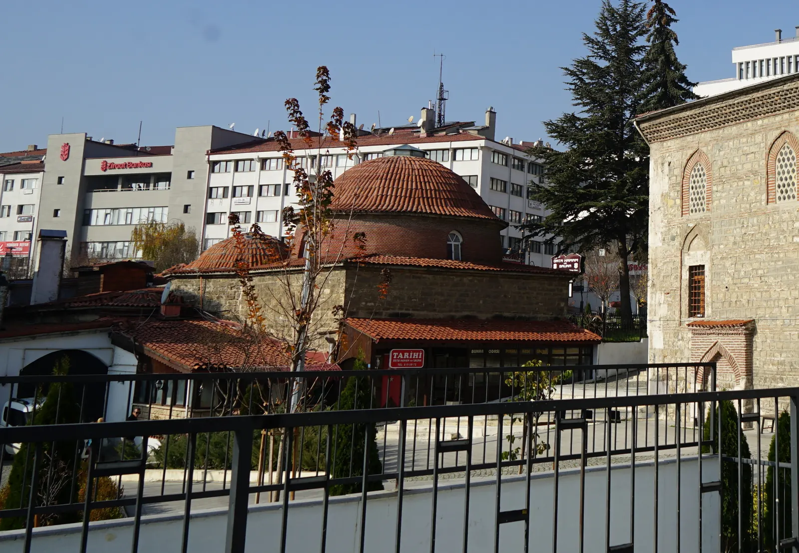 Orta Hamam'ın kiremit kaplı kubbeleri, arkada şehir binaları